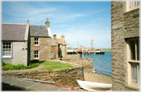 Looking between buildings down to the harbour at Stromness.