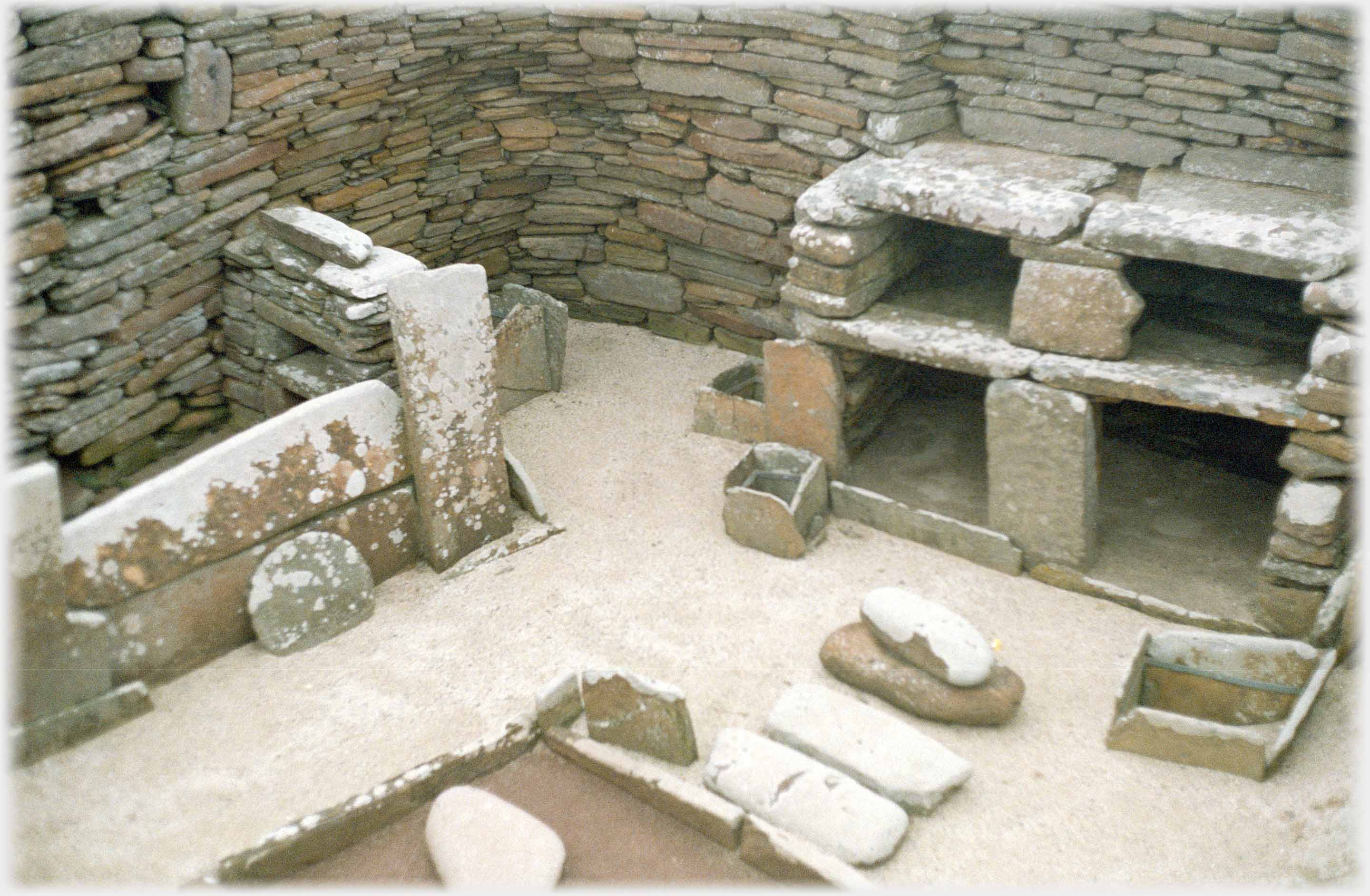 'Living' room with stones forming cupboard and hearth.