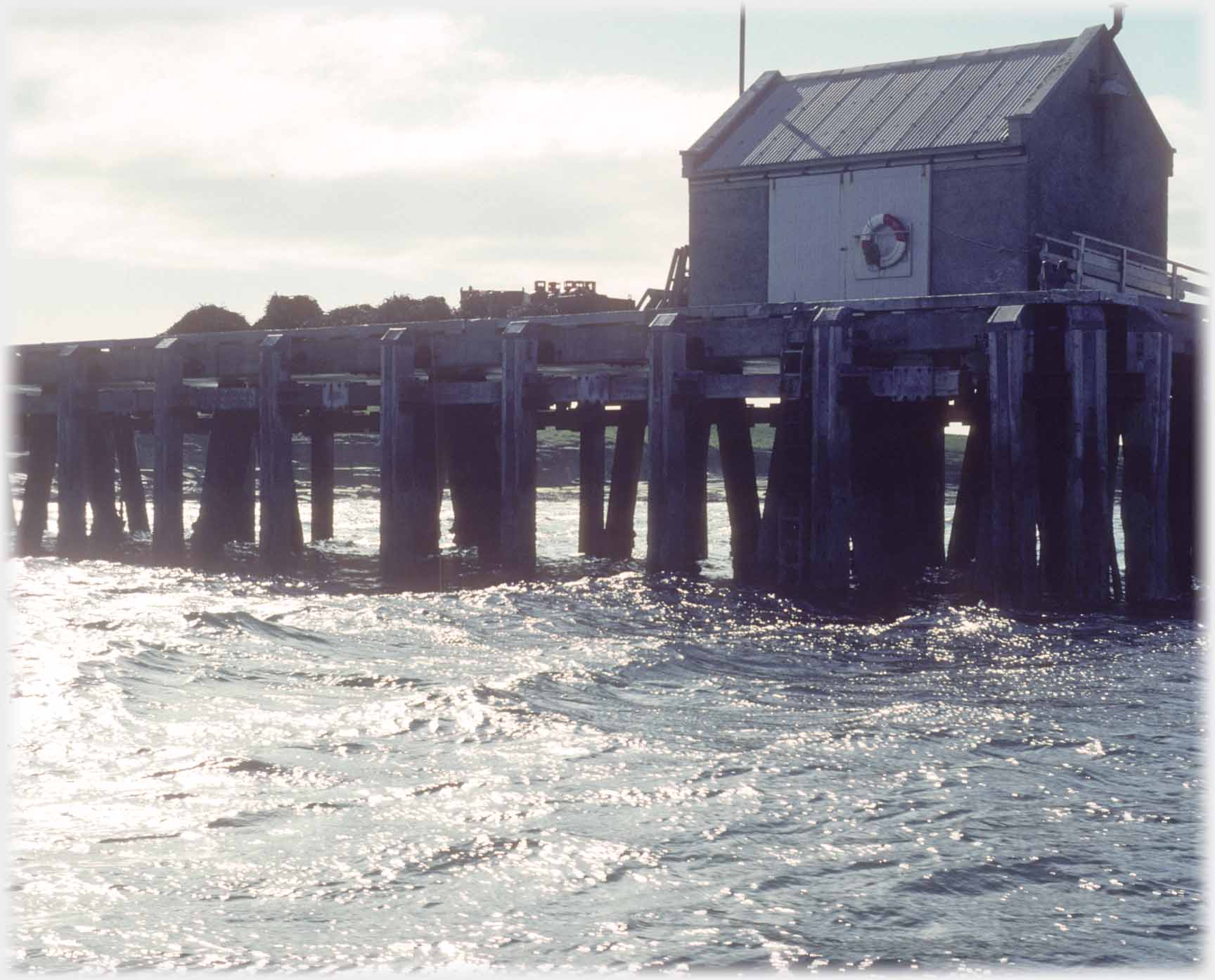 Pier with shed at end from the sea.