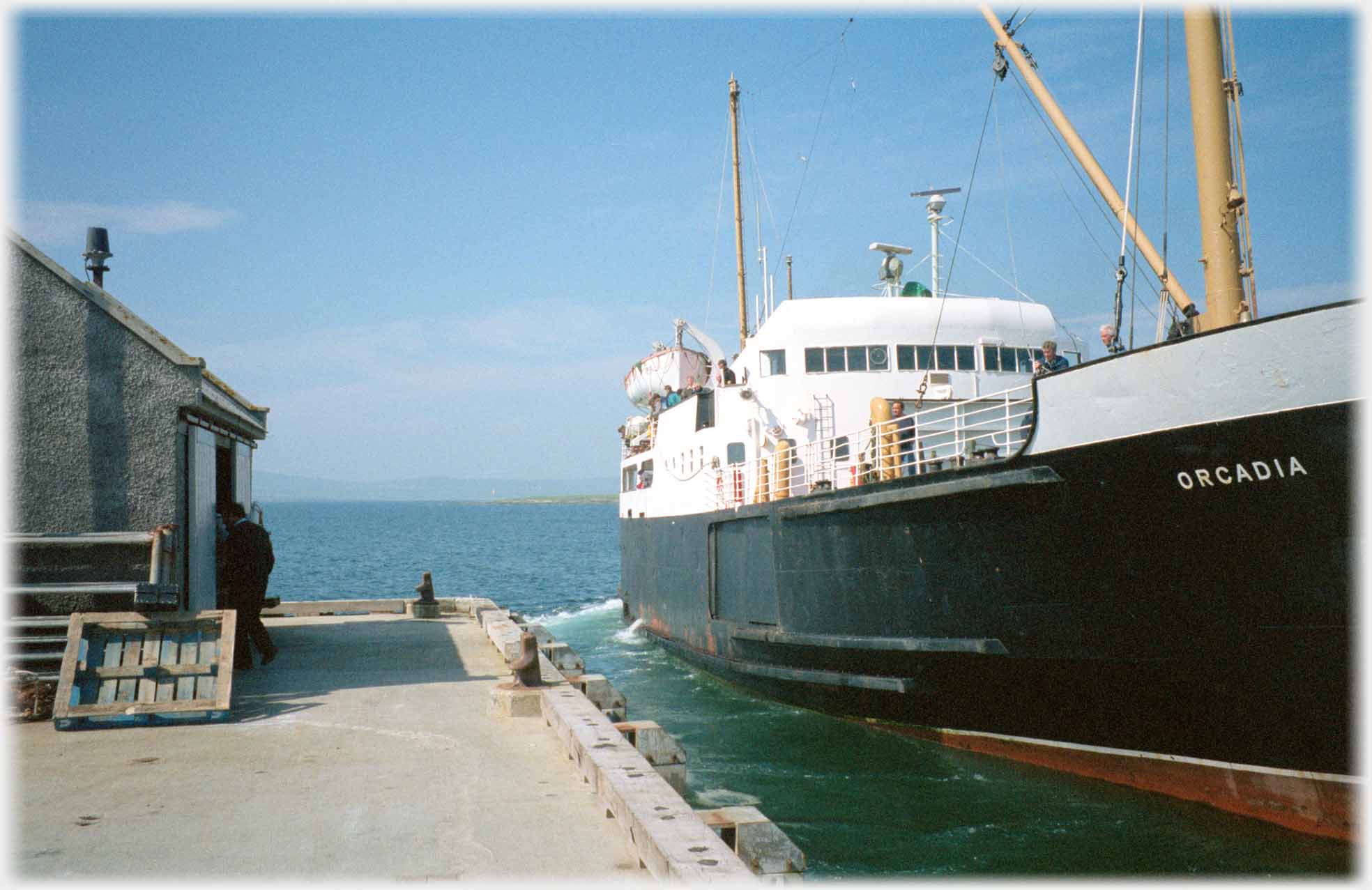 Boat with its name beside pier.