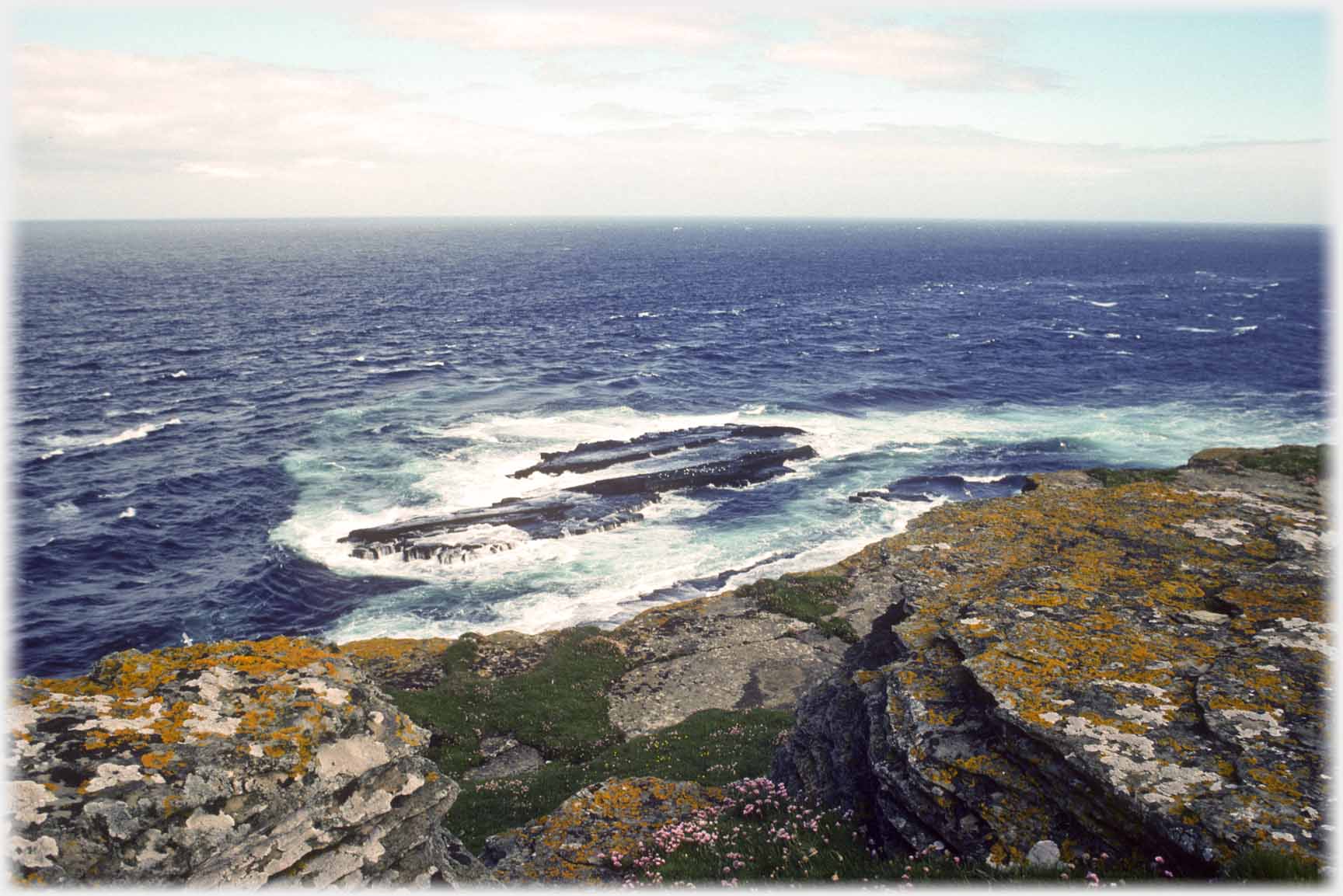 Rocks and white waters near shoreline.