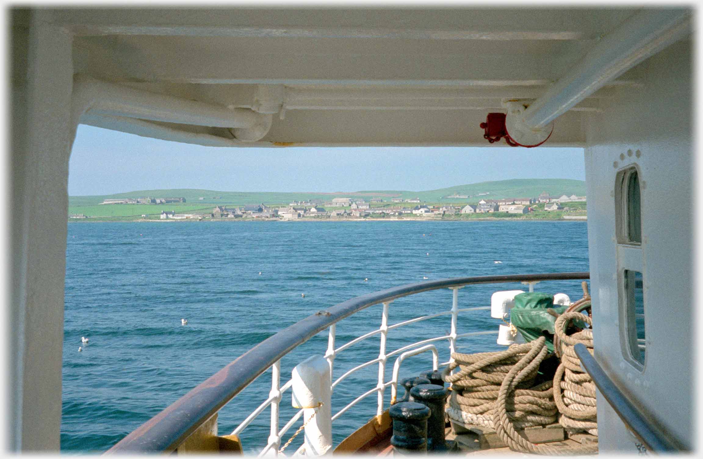 Gangway on ship with land in distance.