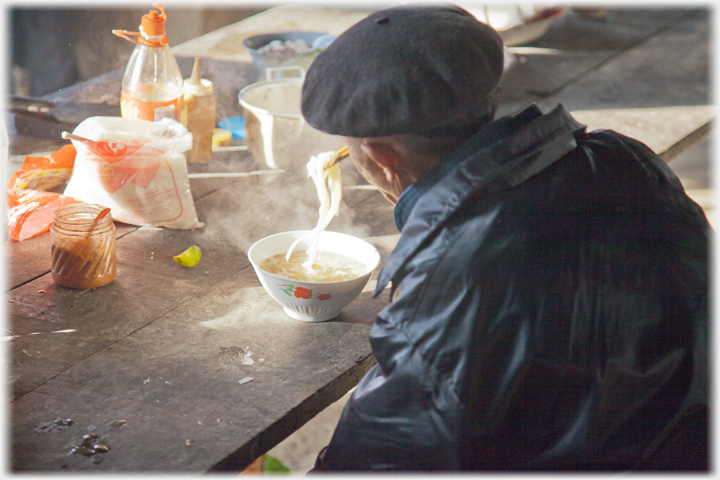 Man eating bowl of Pho.