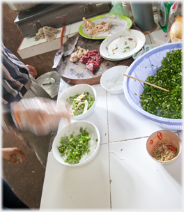 Meat added to bowls.