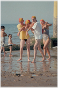 Three life-savers walking with casulty at shoulder height.