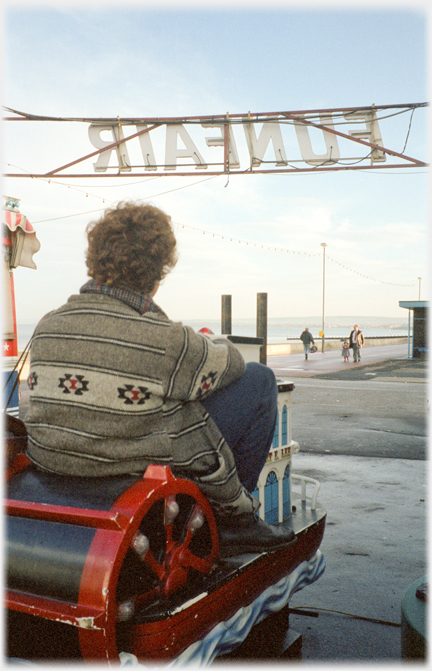 Woman on children's fair ground ride; paddle steamer.