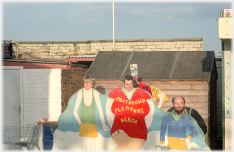 A cutout with place for customers heads above strange bodies.