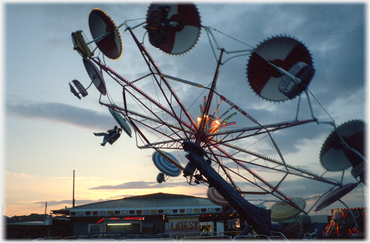 Carousels lifting off above the fairgroound with setting sun behind.