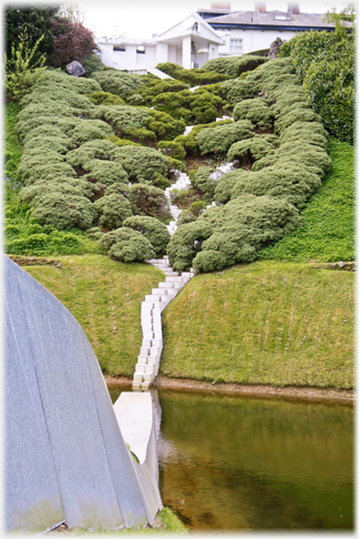 Cascade straight on with pond below and house above.