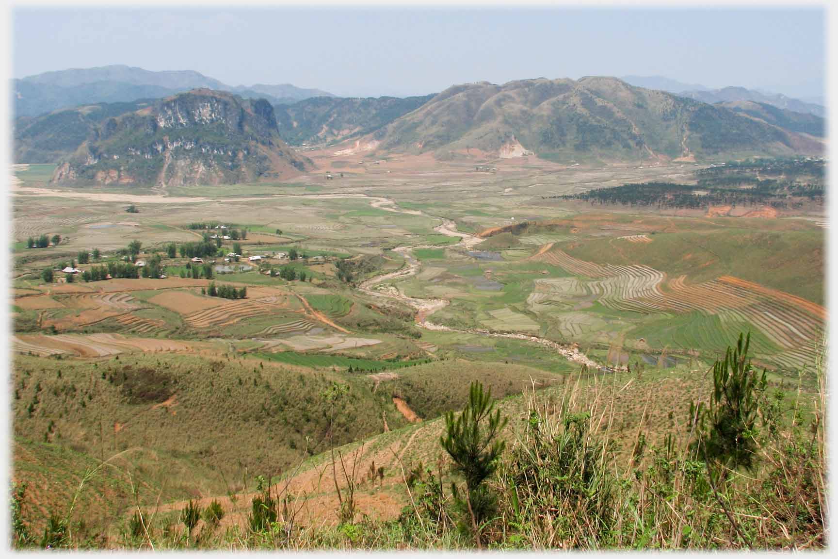 Looking down on wide flat plain with meandering river.