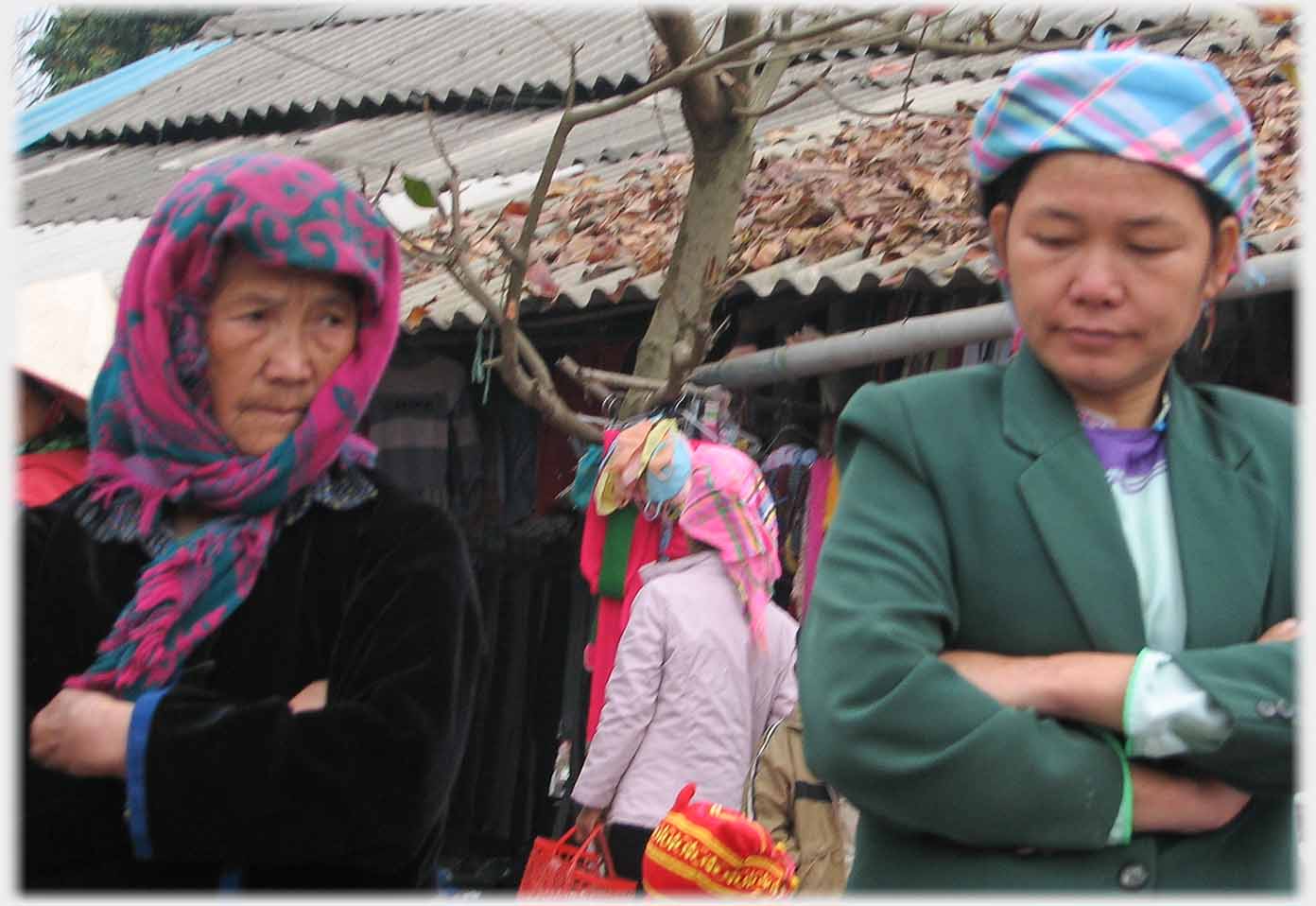 Two women looking down and towards one another.