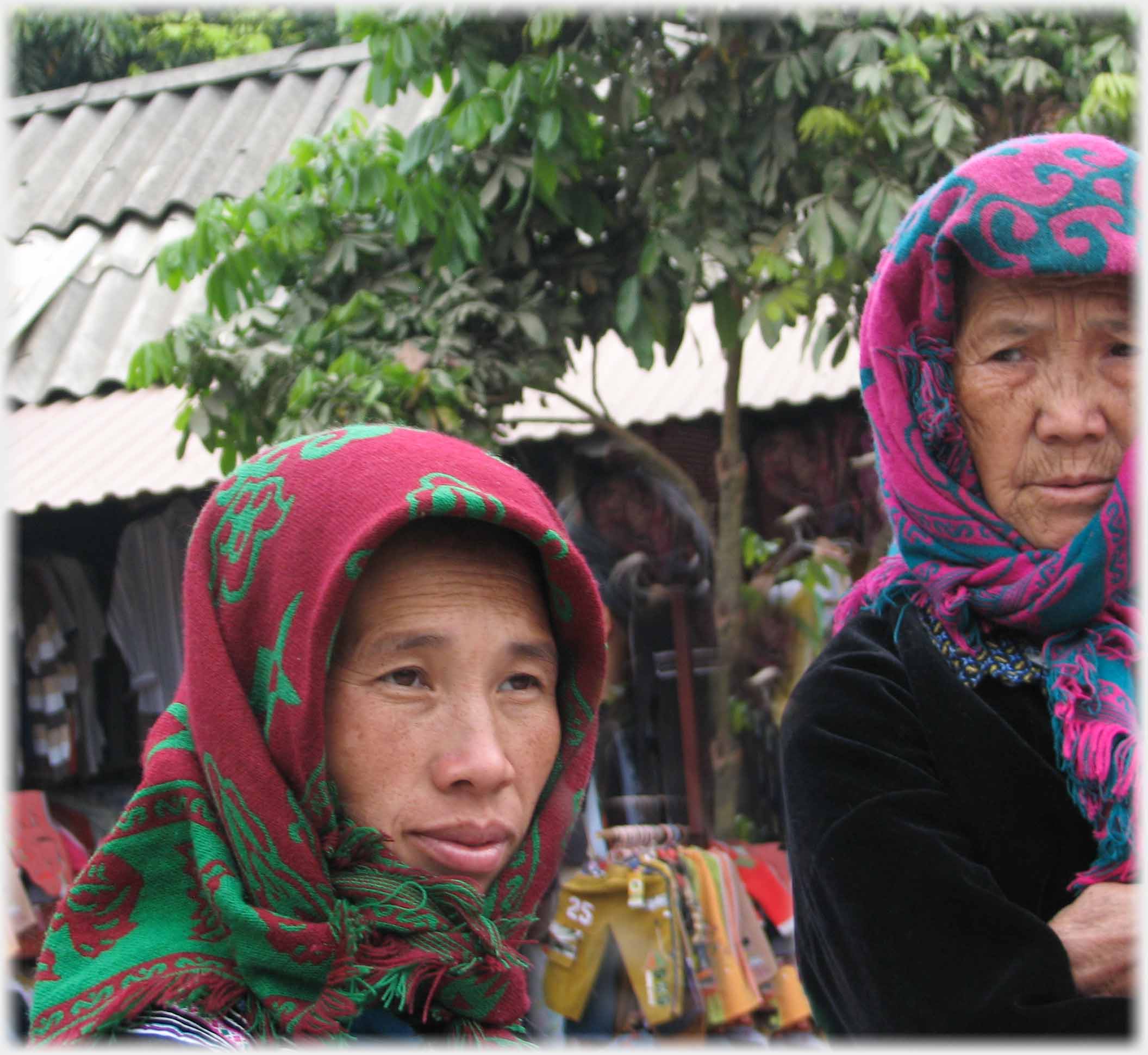 Portrait of women in head scarfs. Older woman looking askance at younger woman.