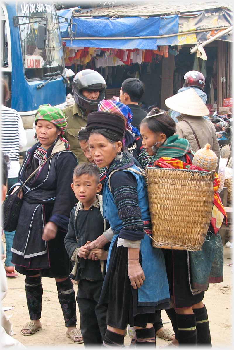 Woman with the back pac with small boy who looks very anxious holding her hand with both of his.