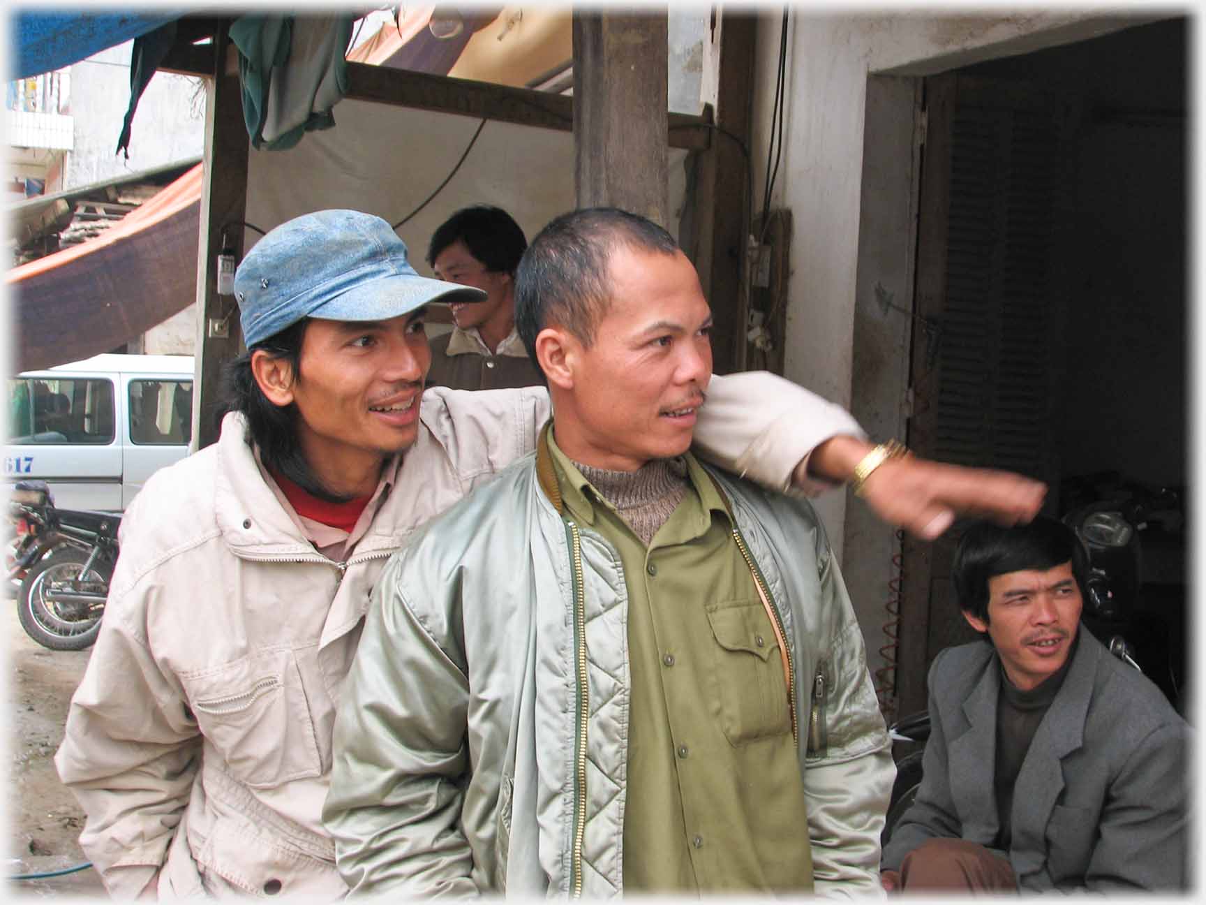 Two men one arm on shoulder of other gesticulating, both looking intently.