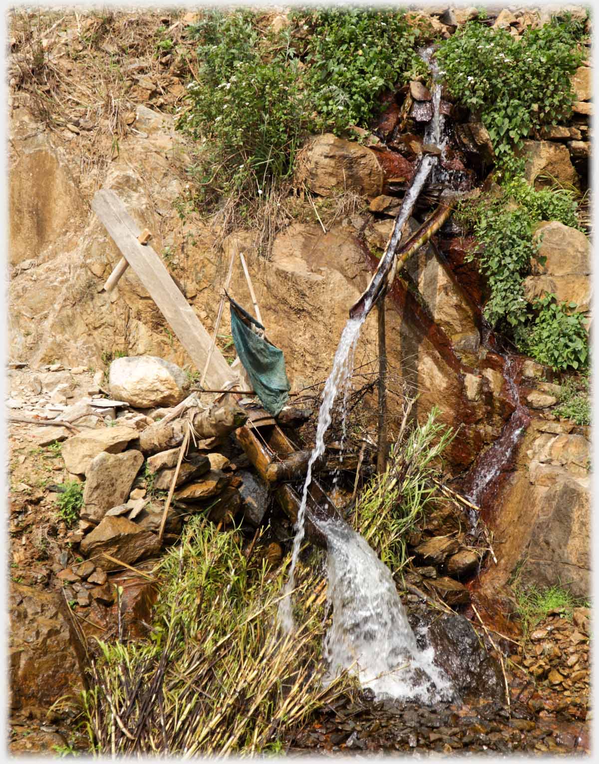 Water running from spout, missing resevoir at other end of beam from dowel, resevoir emptying.