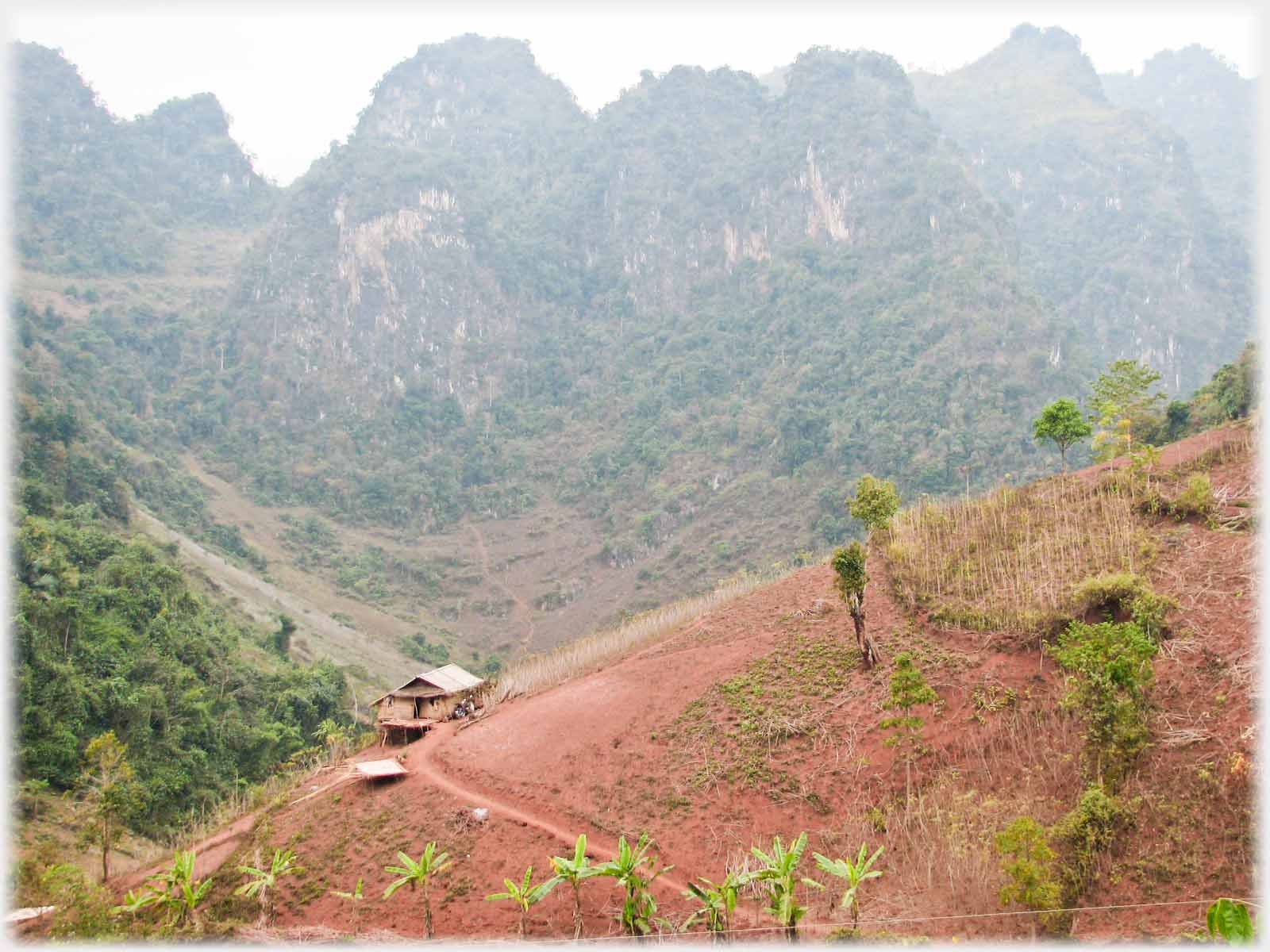 Karst range with track to house perched on hillside in foreground.