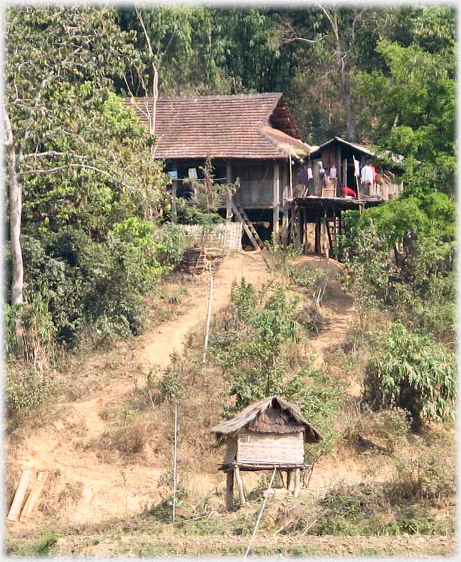 Hut with path up to house that has the typical hipped open ended roof.