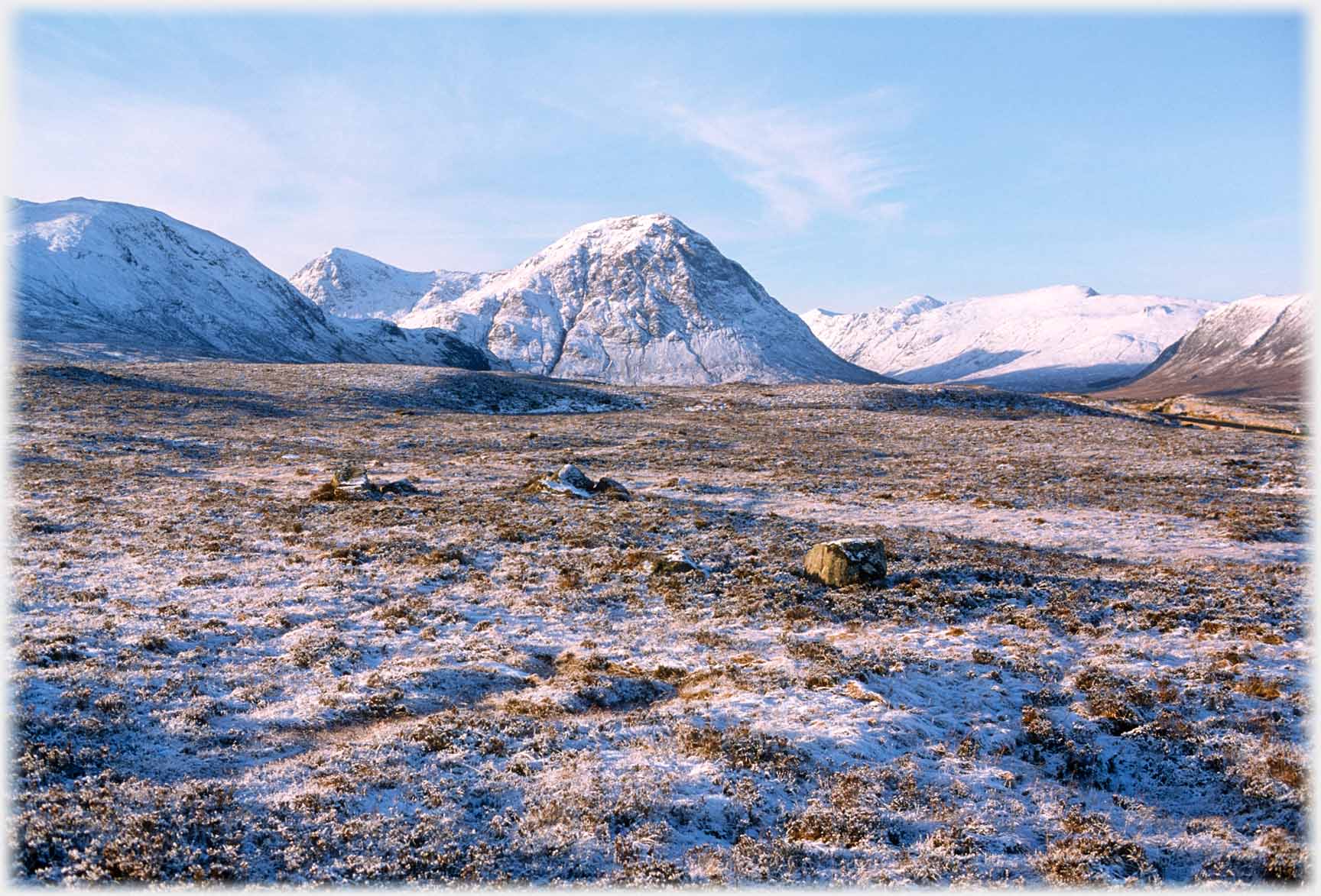 Conical white hill beyond moorland.