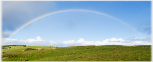 Rainbow against blue sky.