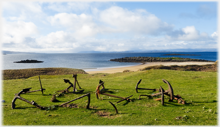 A dozen or so rusted anchors apparently haphazardly placed.