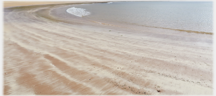 Strange soft markings along lines left by the waves, on which are some scattered stones.