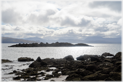 Dark rocks with dark clouds above the sea.