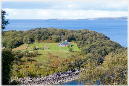 House on peninsular with trees around it.