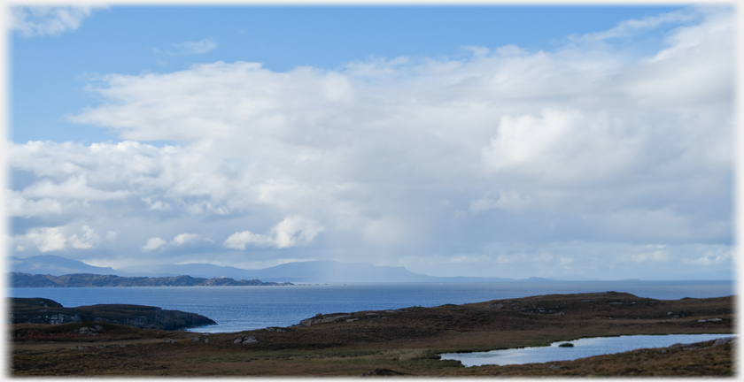 View out to sea with small loch near and the skye hills distant.