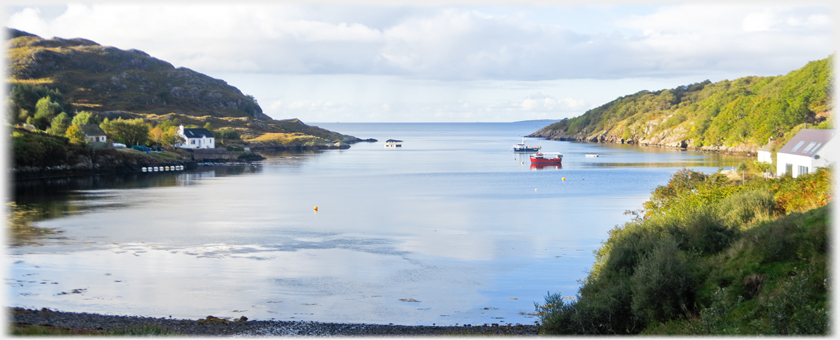 Bay with sea beyond, two boats at anchor.