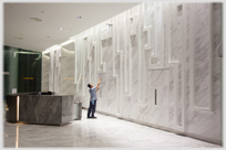 Man cleaning office entrance wall.