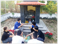 Family group lunching beside grave.
