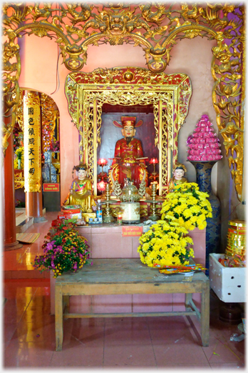 Side altar with large varses of flowers.