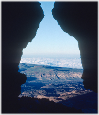 Gap through rocks to clouds below.