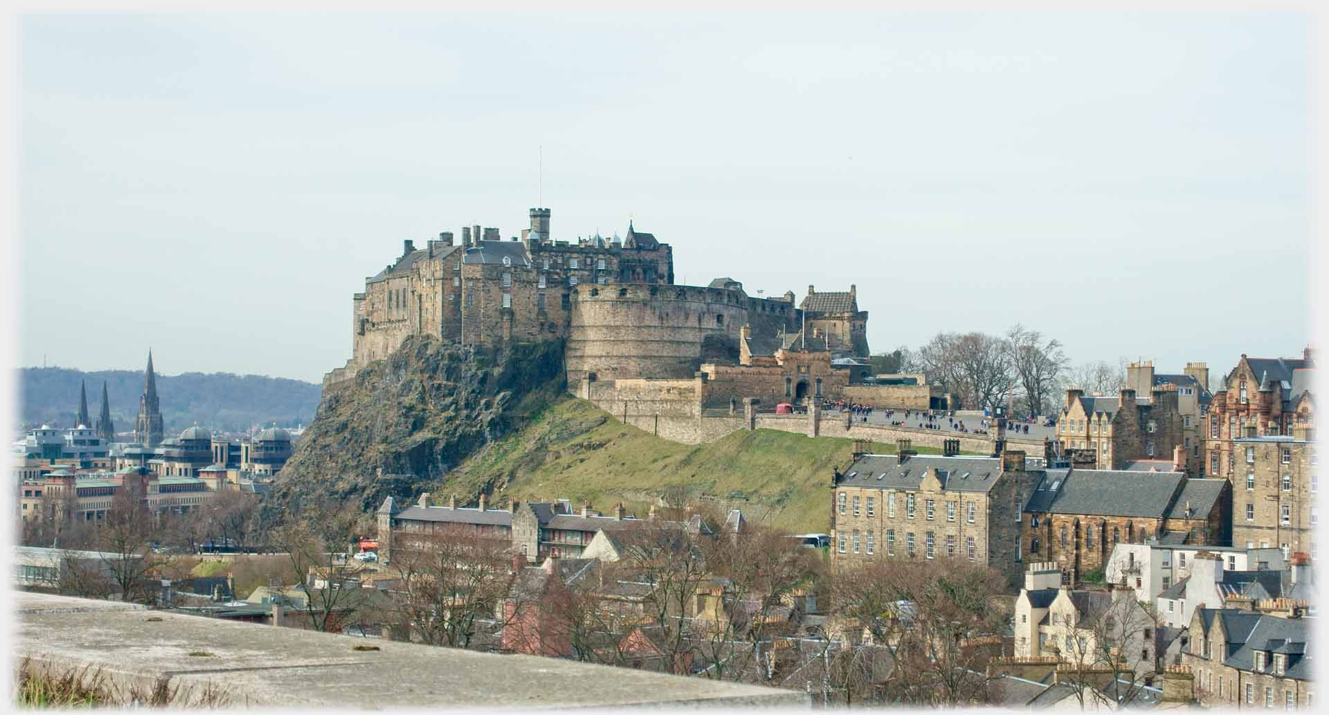 Castle on steep hill, town around.