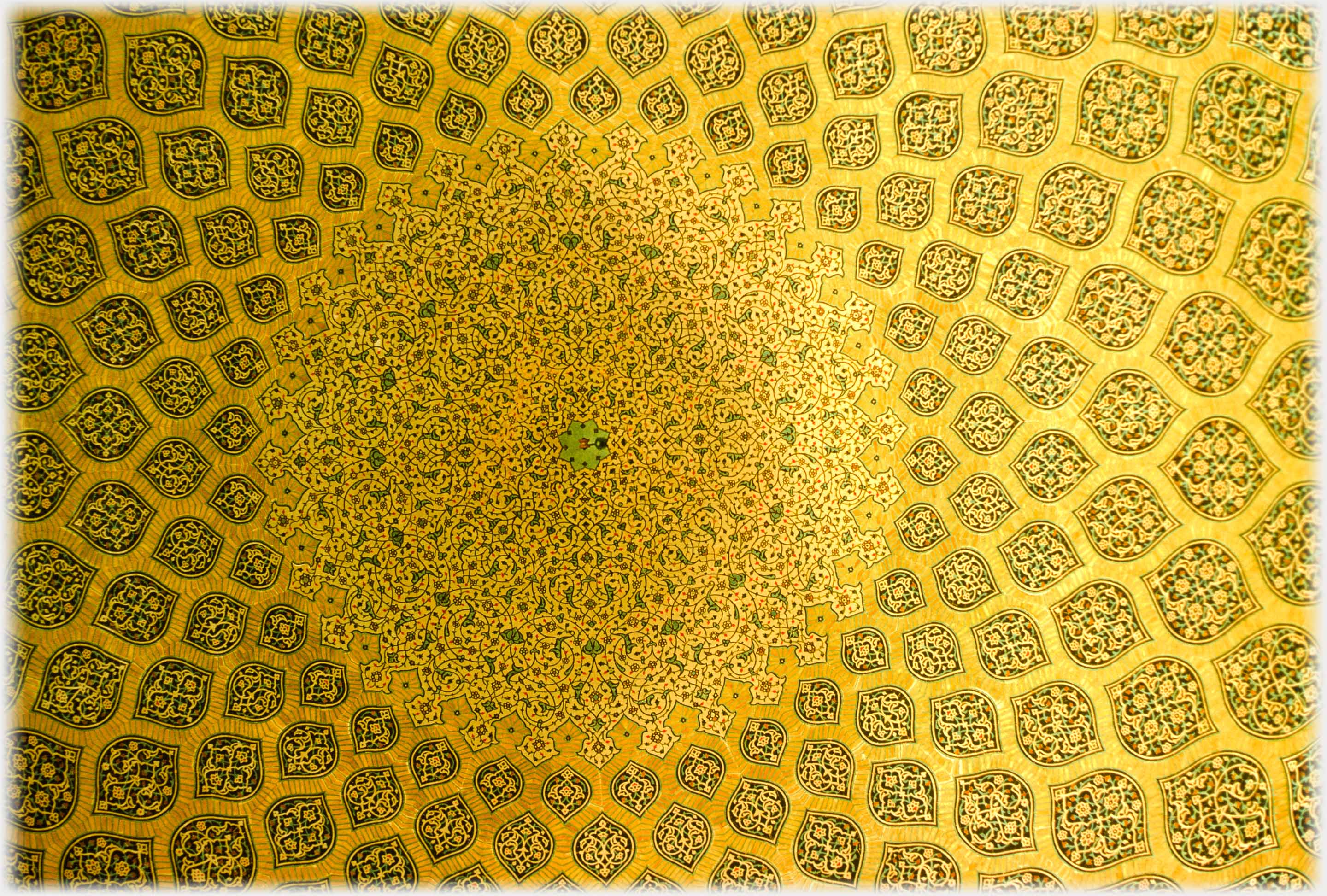 Looking up at the pattern of tiles within a mosques dome.