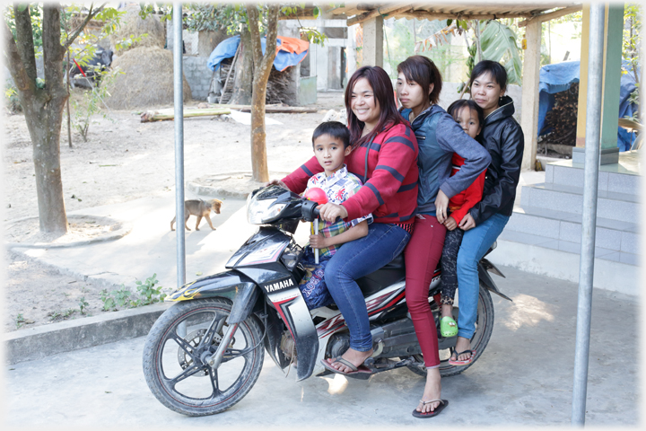 Three women and two children leaving on their motorbike.