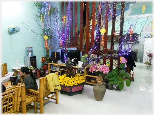 Tree branches with neon lights around them in modern living area.