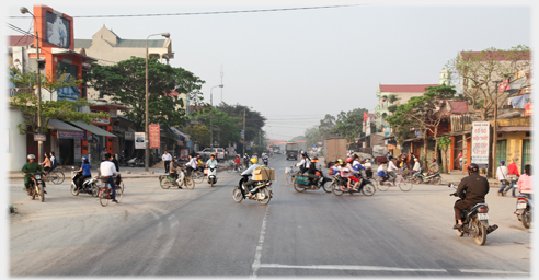 Crossroad with cyclists and motorcyclists all interlocking.