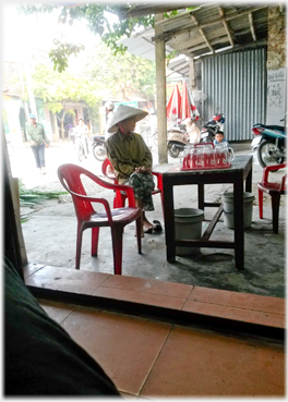 Be-hatted person sitting at outside table.