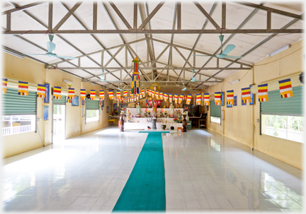 The whole room with bare marble floor and flags hanging.