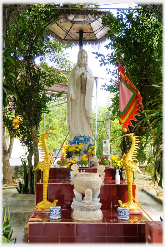 Buddha statue with cranes and incense urn.