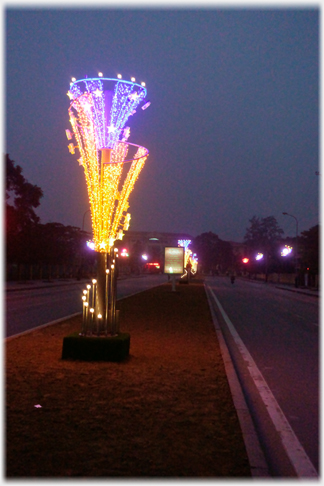 Large inverted cone of lights by roadside.