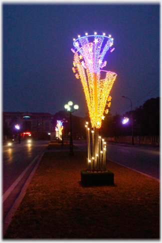 Large inverted cone of lights, distant motorbike light.