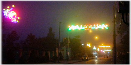 Lights across street and on lampposts at side.