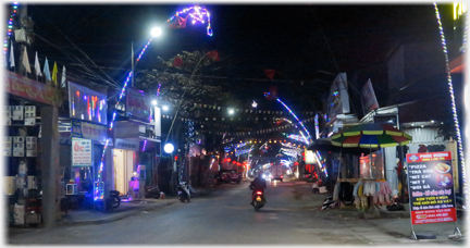 Distant lights along street with food shops towards front