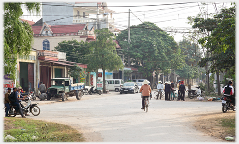 Cross roads further out of town with people standing by corners.