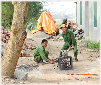 Two men working a cutting machine on a gap site.