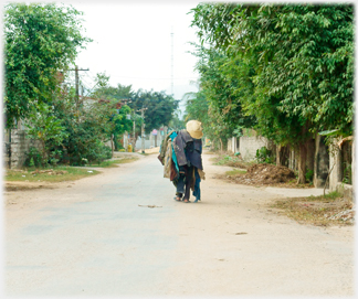 Sort of double figure with womans hat on one side walking away down the road.