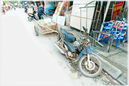 Motorbike with trailer attached outside homeware shop.