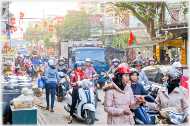 View of street packed with people and vehicles.